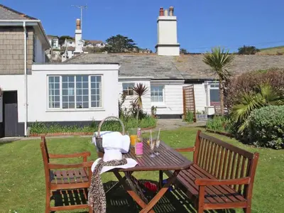 a wooden table with two chairs and a table with wine glasses at Watchtower in Torpoint