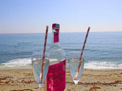 two wine glasses and a bottle on the beach at Watchtower in Torpoint