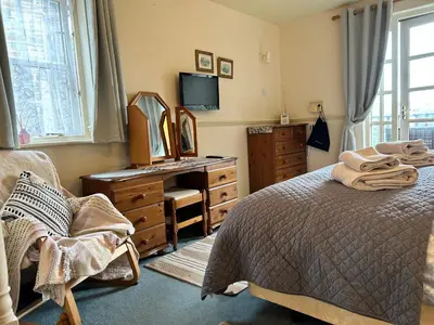 a bedroom with a bed and a dresser and a mirror at Looe, Cornwall, Cottage, couples, romantic, quiet location, views, reliable Wi-Fi in Looe