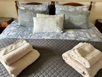 a bed with pillows and towels on top of it at Looe, Cornwall, Cottage, couples, romantic, quiet location, views, reliable Wi-Fi in Looe