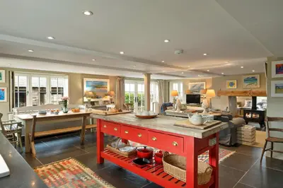 a large kitchen with a red island in a room at Finest Retreats - St Eval School House in Saint Ervan