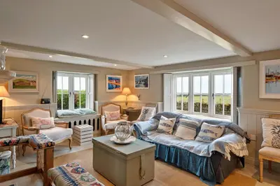 a living room with a couch and chairs and windows at Finest Retreats - St Eval School House in Saint Ervan