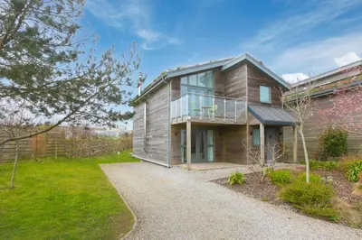 a wooden house with a balcony and a yard at 64 Una in Carbis Bay