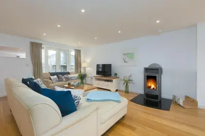 a living room with a couch and a fireplace at 64 Una in Carbis Bay