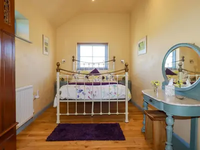 a bedroom with a bed and a sink and a mirror at Stargazy Skies in St. Agnes