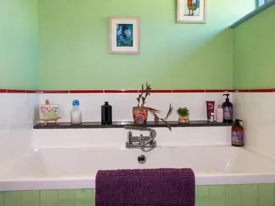 a large white bath tub with a purple towel at Stargazy Skies in St. Agnes