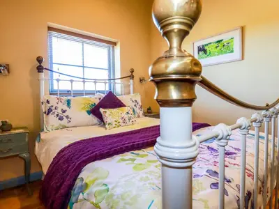 a bedroom with a bed with a metal frame at Stargazy Skies in St. Agnes