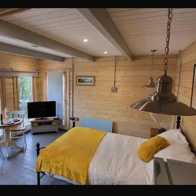 a bedroom with a bed with a yellow blanket at Sea La Vie in Perranporth