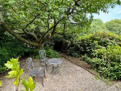 a table and two chairs and a tree at The Hayloft in Lostwithiel