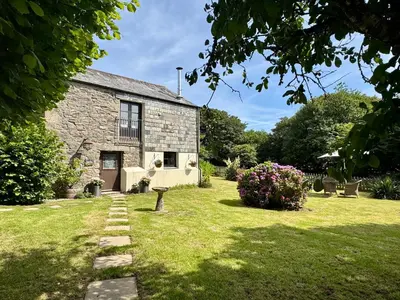an old stone house with a grass yard at The Mill in Lostwithiel