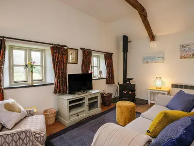 a living room with a couch and a tv at The Mill in Lostwithiel