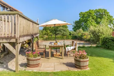 a patio with a table and an umbrella at 2 Bed in Launceston oc-t31002 in Lewannick