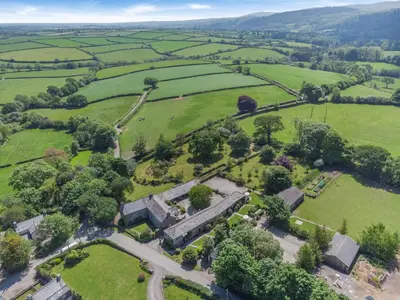 an aerial view of a field with trees and buildings at 2 Bed in Launceston oc-t31002 in Lewannick