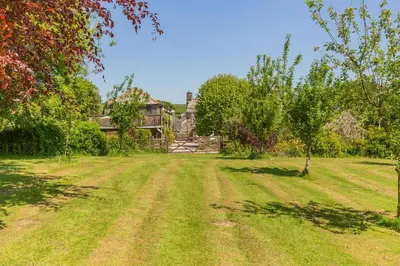 a field of grass with a house in the background at 2 Bed in Launceston oc-t31002 in Lewannick
