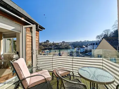 a balcony with chairs and a glass table with a view at 2 Bed in Fowey oc-o31260 in Fowey