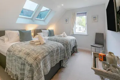 a bedroom with two beds and a chair at 2 Bed in Fowey oc-o31260 in Fowey