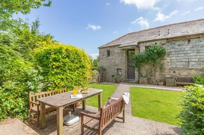 a wooden table and benches in the garden of a house at 2 Bed in Launceston oc-d31000 in Lewannick