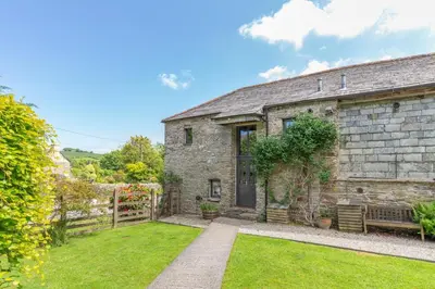 an old stone house with a bench in the yard at 2 Bed in Launceston oc-d31000 in Lewannick