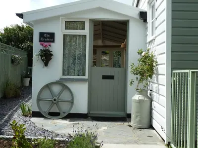 a front door of a white house with a green door at Birdsong in St. Issey