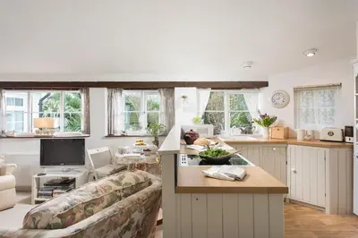 a living room with a couch and a kitchen at Birdsong in St. Issey