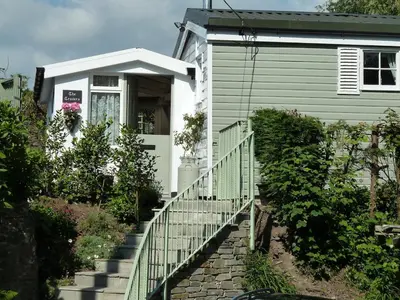 a house with a staircase leading up to a porch at Birdsong in St. Issey