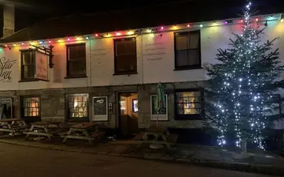 a christmas tree in front of a building with lights at The Star Inn in Saint Erth