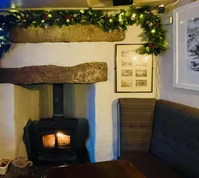 a fireplace in a room with a christmas decoration at The Star Inn in Saint Erth