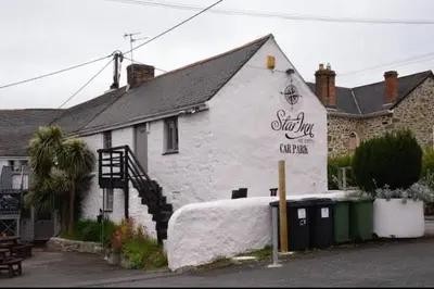 a white building with a sign on the side of it at The Star Inn in Saint Erth