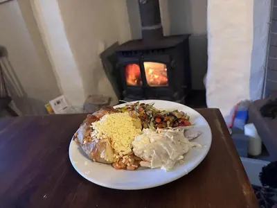 a plate of food on a table in front of a stove at The Star Inn in Saint Erth