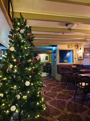 a christmas tree in a room with tables and chairs at The Star Inn in Saint Erth