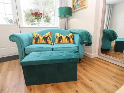 a blue couch in a living room with a mirror at Elder Cottage Studio in Truro