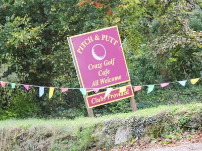 a sign for a crazy golf club with flags at Elder Cottage Studio in Truro