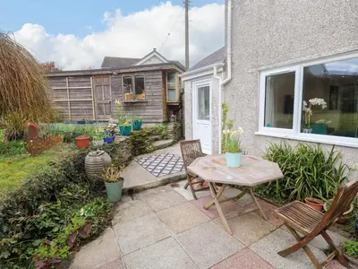 a patio with a table and chairs in a yard at Elder Cottage Studio in Truro