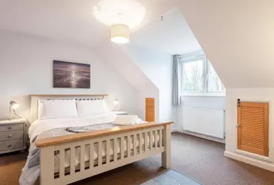 a bedroom with a large bed and a window at Family Home in Hayle close to Gwithian Beach in Phillack