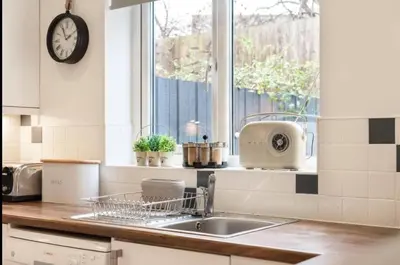a kitchen sink with a dish drying rack next to a window at Family Home in Hayle close to Gwithian Beach in Phillack