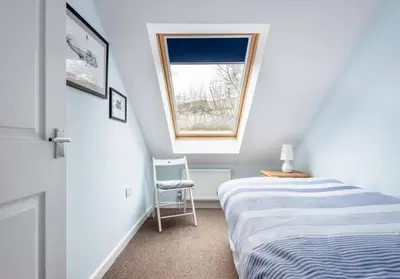 a small bedroom with a bed and a window at Family Home in Hayle close to Gwithian Beach in Phillack