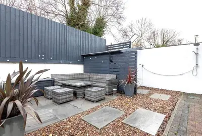 a patio with a couch and a table in a yard at Family Home in Hayle close to Gwithian Beach in Phillack
