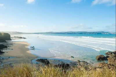 a view of a beach with the ocean and rocks at Family Home in Hayle close to Gwithian Beach in Phillack