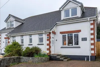 a white house with a black roof at Family Home in Hayle close to Gwithian Beach in Phillack