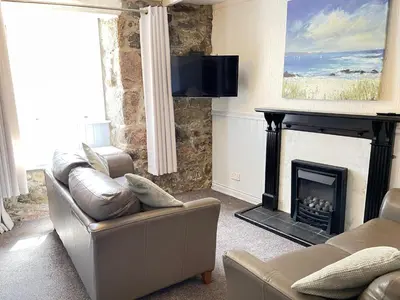 a living room with a couch and a fireplace at Penty Men Growyn in St Ives