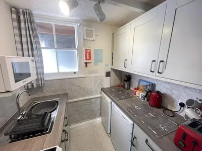 a small kitchen with white cabinets and a sink at Penty Men Growyn in St Ives
