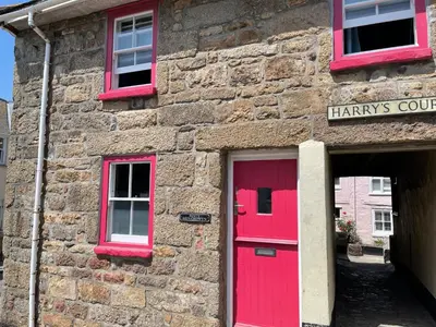 a brick building with a red door and two windows at Penty Men Growyn in St Ives