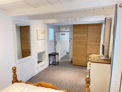 a room with a bed and a refrigerator and a door at Norway House Studio in St Ives