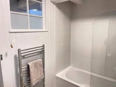 a white bathroom with a shower and a sink at Norway House Studio in St Ives