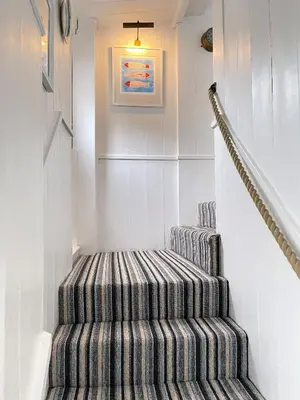 a striped staircase in a house with a picture on the wall at Norway House Studio in St Ives