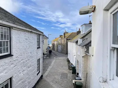 an alley between two buildings with a person walking down the street at Windjammer in St Ives
