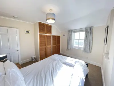 a bedroom with a large white bed with a window at Windjammer in St Ives