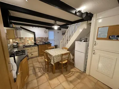 a kitchen with a table and a white refrigerator at Windjammer in St Ives