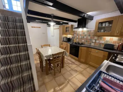 a kitchen with a table and a dining room at Windjammer in St Ives