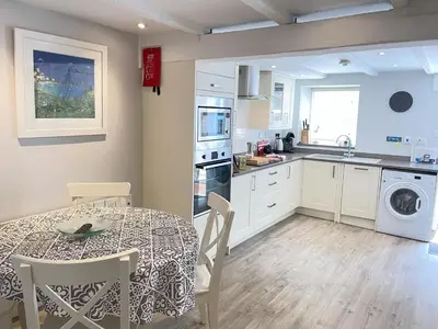 a kitchen and dining room with a table and a table and chairs at Howards Way in St Ives